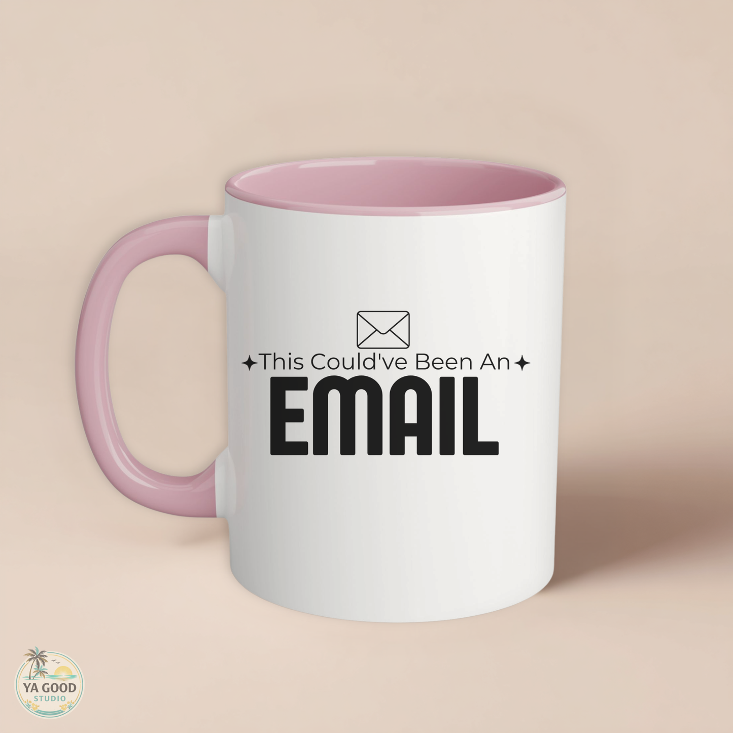 White mug with pink handle featuring text 'This Could've Been An Email' on a beige background