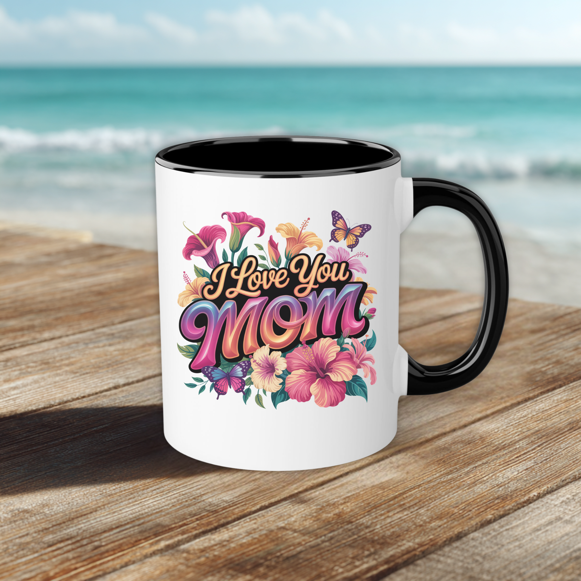 white mug with black trim that says "I Love you Mom" in floral pattern on bench with blurred background