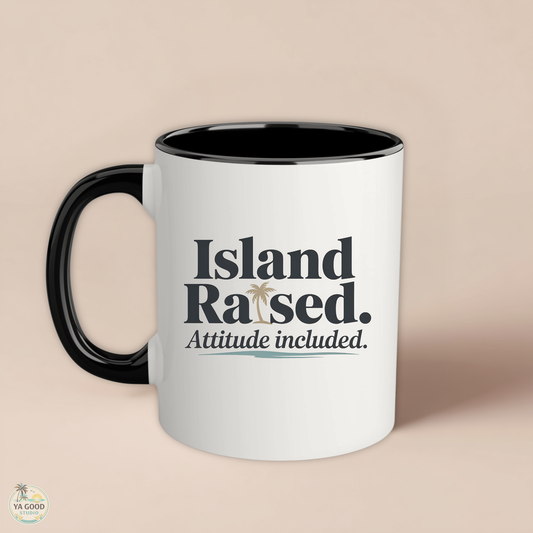 White mug with black interior and handle, featuring 'Island Raised. Attitude included.' text on a beige background.