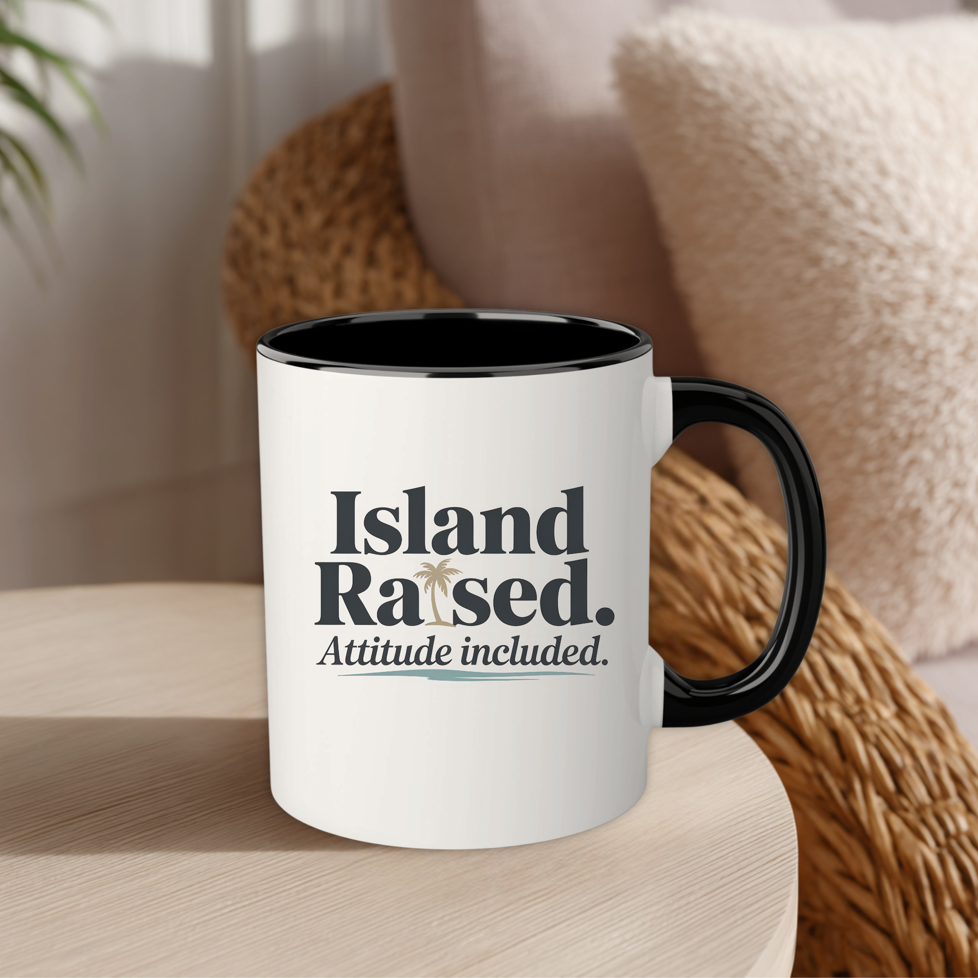 White mug with black interior and handle, featuring text 'Island Raised. Attitude included.' on a wooden surface.