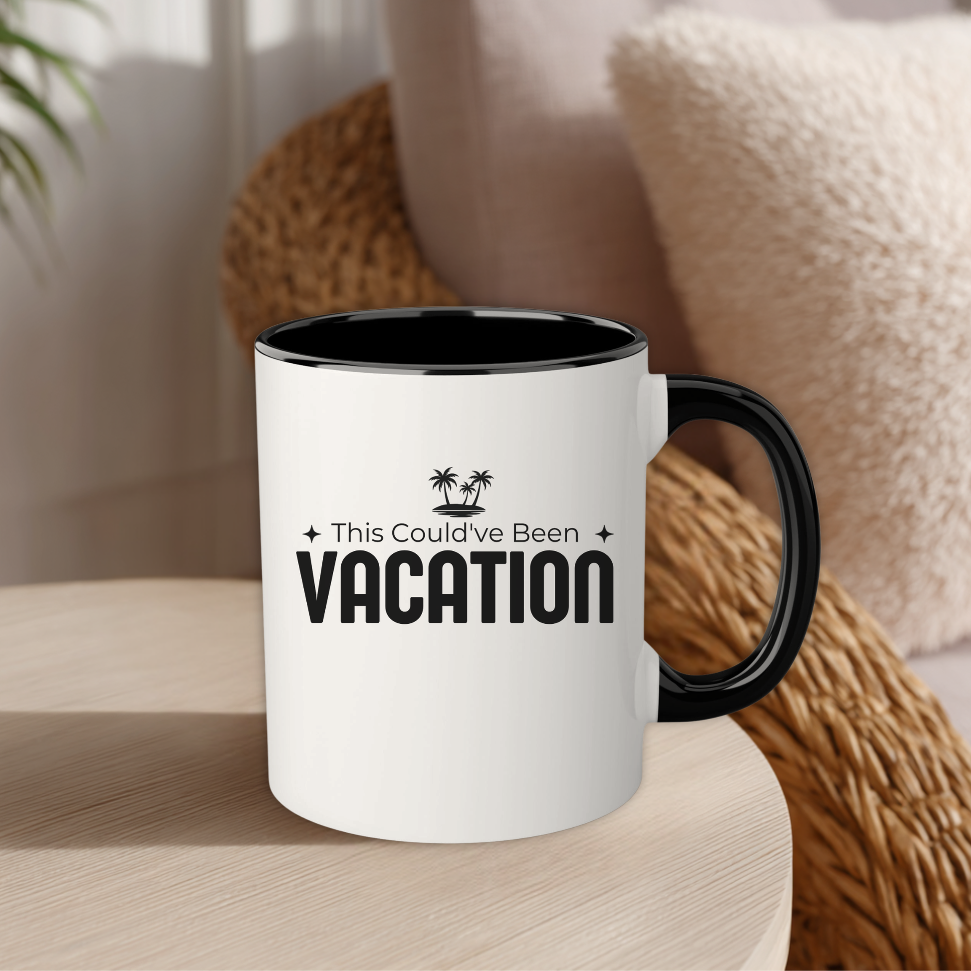White mug with black interior and handle, featuring 'This Could've Been Vacation' text, on a wooden surface.