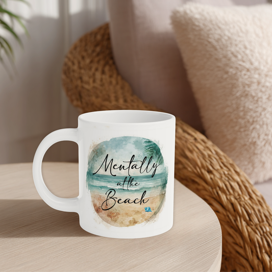 White mug with beach-themed design and text on a wooden surface.